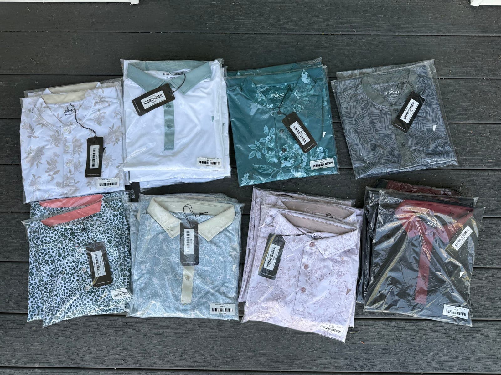 Folded Primo golf polos laid out flat on a deck