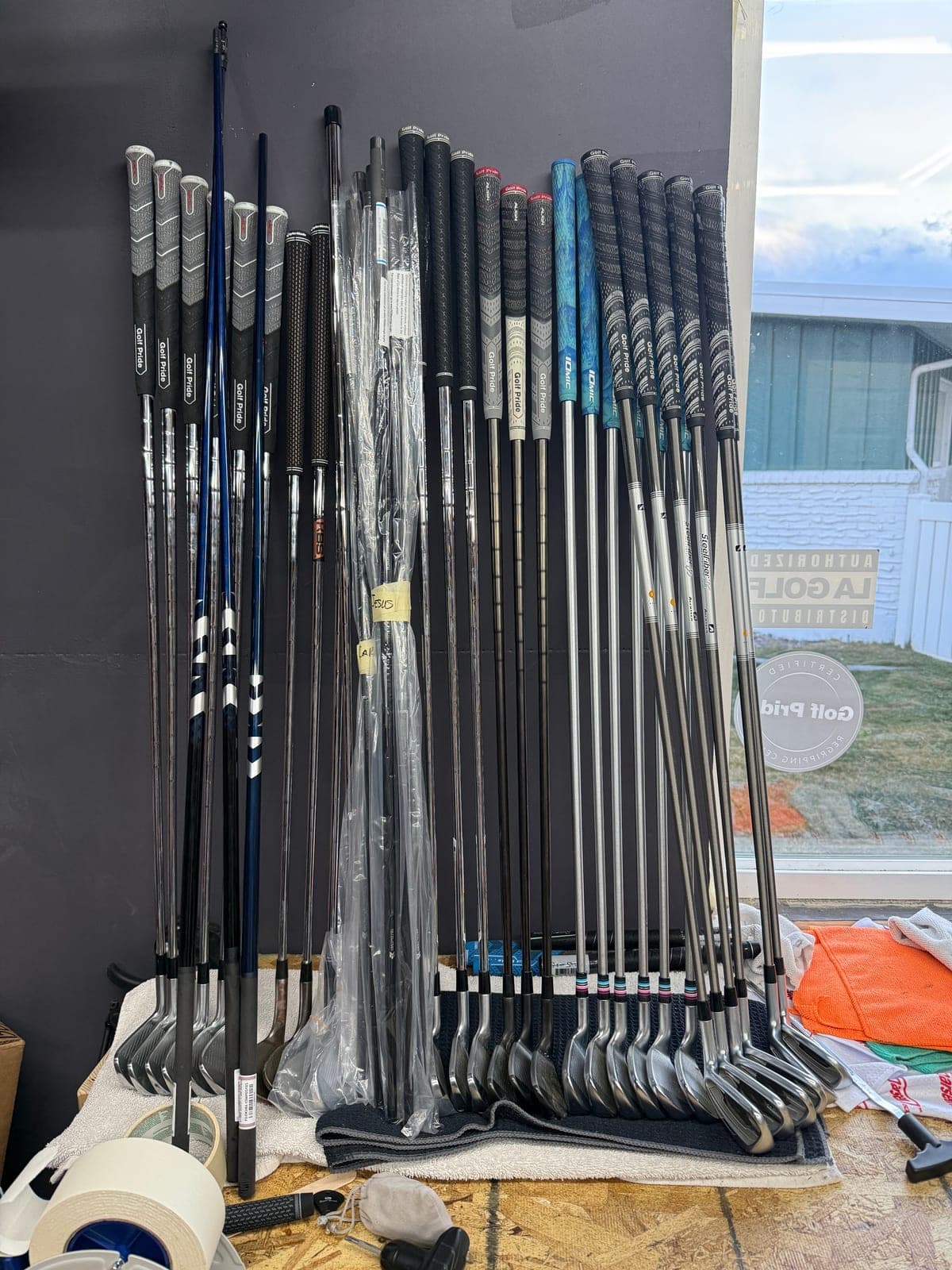 Shafts, grips, and iron heads leaning against the shop wall