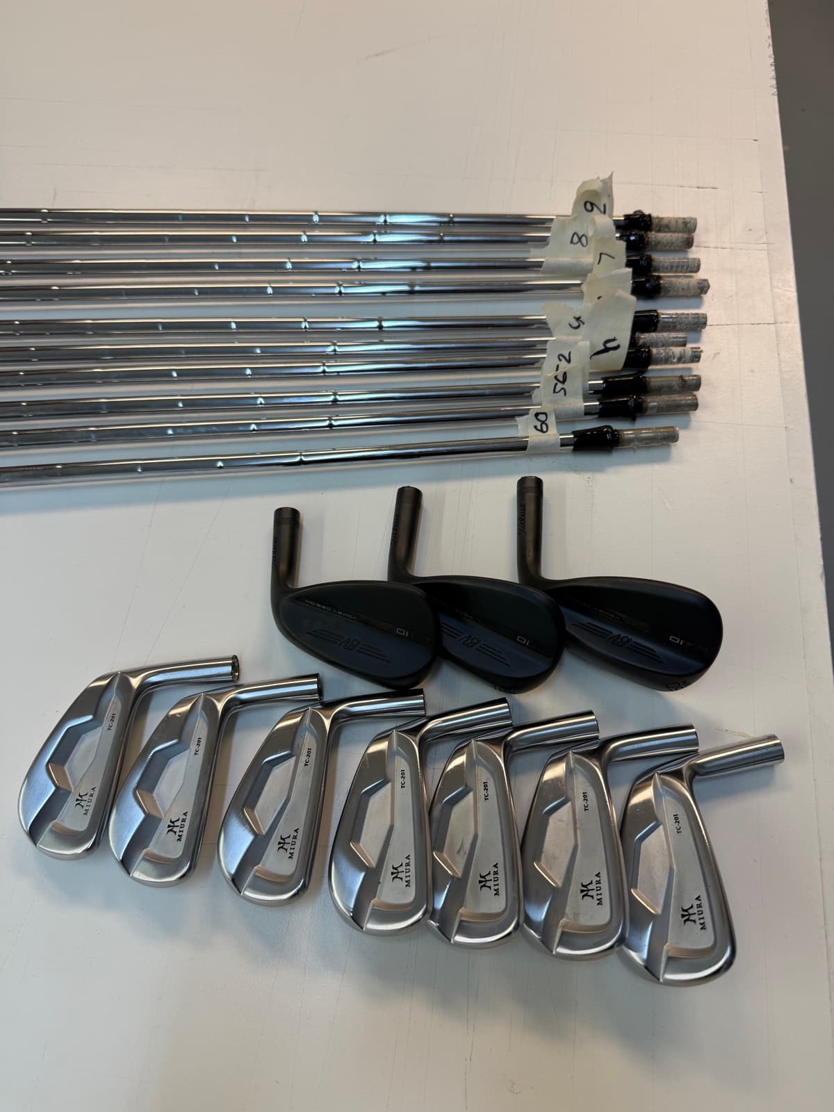 Miura iron heads and shafts staged together for a build