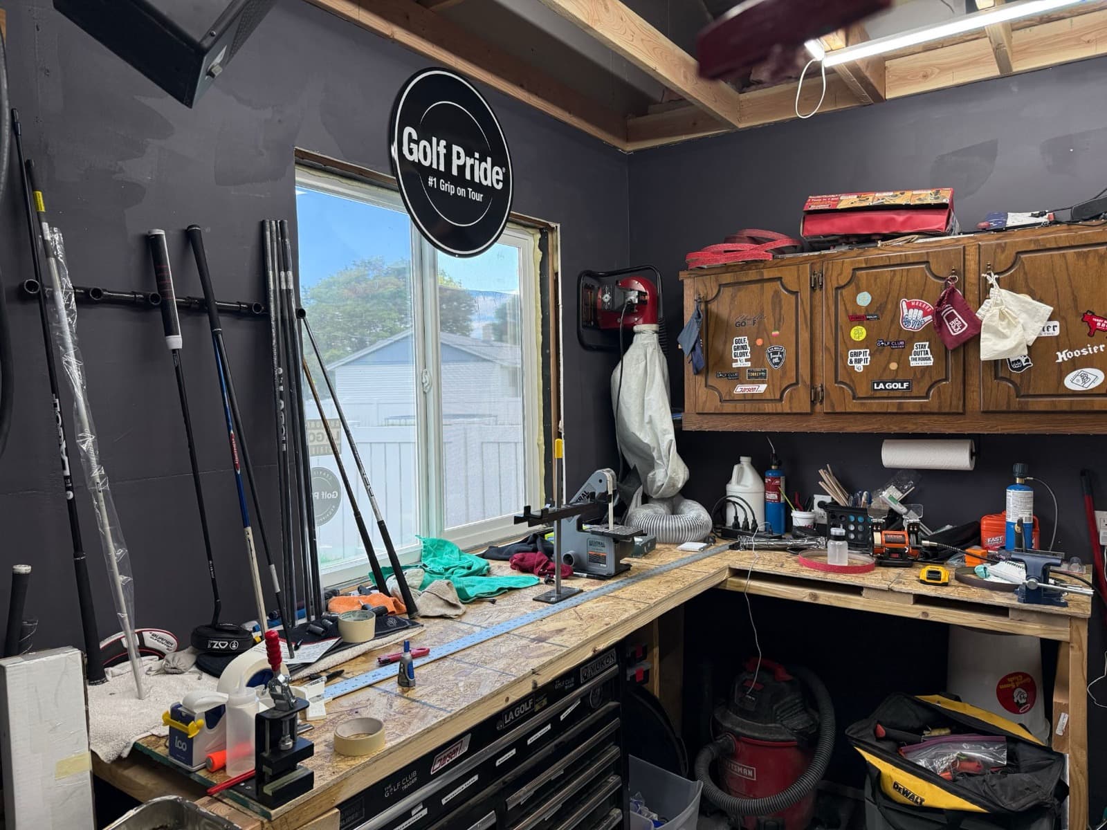 Club building workbench with a Golf Pride sign on the wall