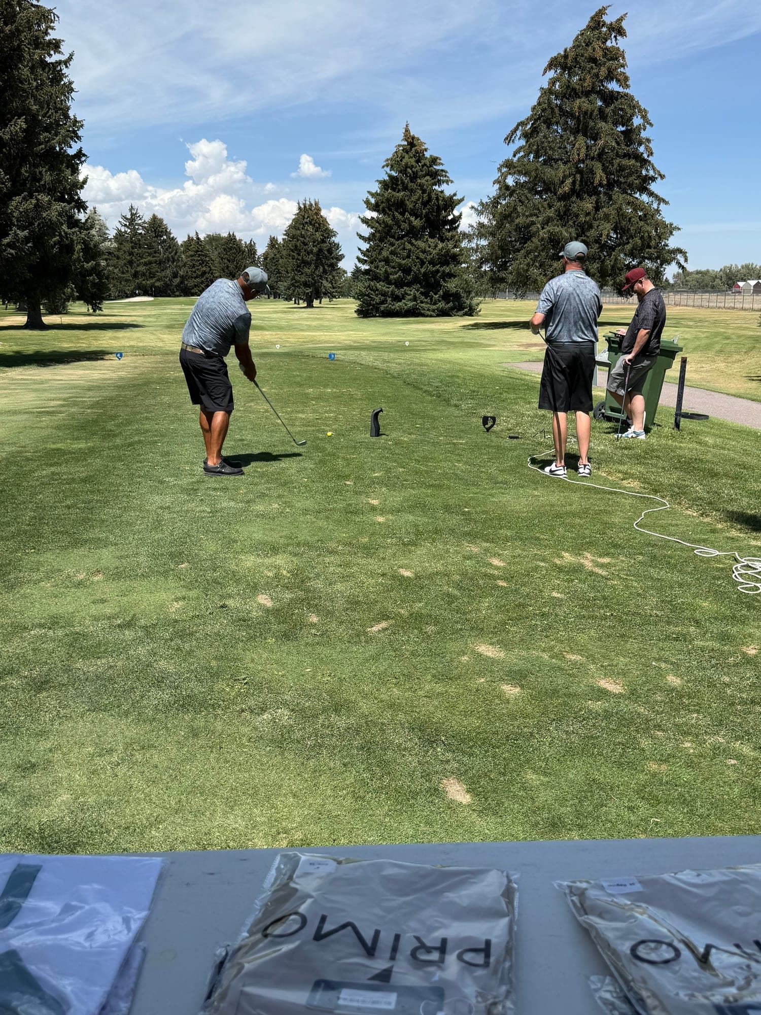 Hayden coaching a customer on the tee box during an outdoor fitting session