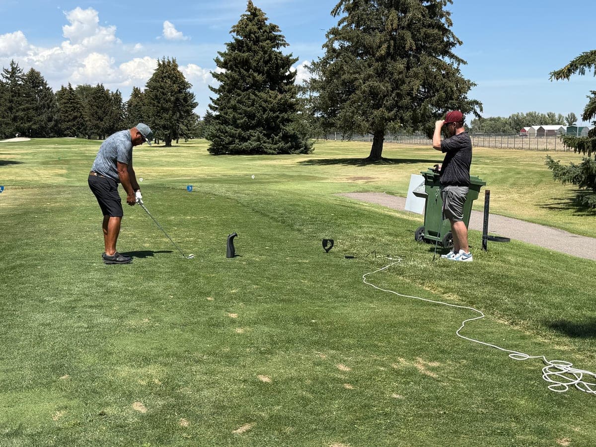 Golfer at address on the tee box during an outdoor fitting session