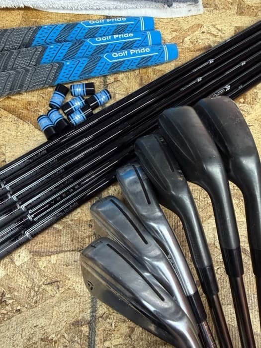 Grips, shafts, and iron heads laid out on the shop floor